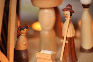 A warmly lit handcrafted nativity scene with intricate figurines and rustic textures.