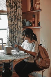 A woman reading a menopause guidebook in a cozy living room.