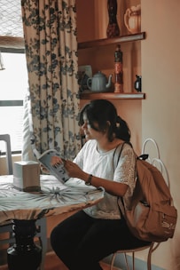 A woman reading a menopause guidebook in a cozy living room.
