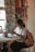 A woman reading 'the meaning(s) of your life!' in a cozy setting.