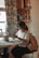 A woman reading 'the meaning(s) of your life!' in a cozy setting.