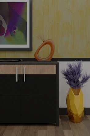 A modern interior scene featuring a cabinet with a sleek black and wood finish. On top of the cabinet, there is an abstract orange sculpture with a circular design and a flat decorative element. A framed abstract painting hangs on the wall above, displaying a variety of colors including purple, green, and blue. To the right of the cabinet, a geometric yellow vase holds dried branches, adding a touch of natural texture. The background features a textured yellow wallpaper, complementing the wooden floor.