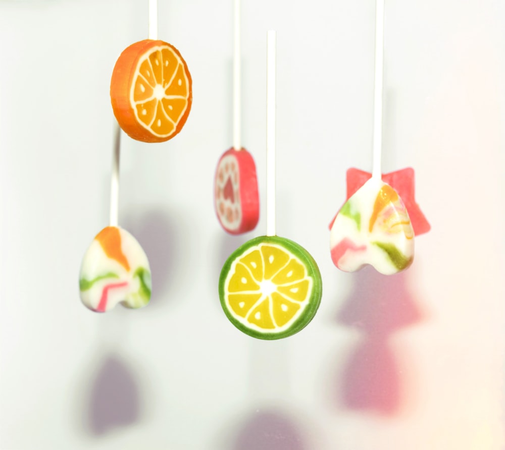 a group of fruits hanging from strings on a wall