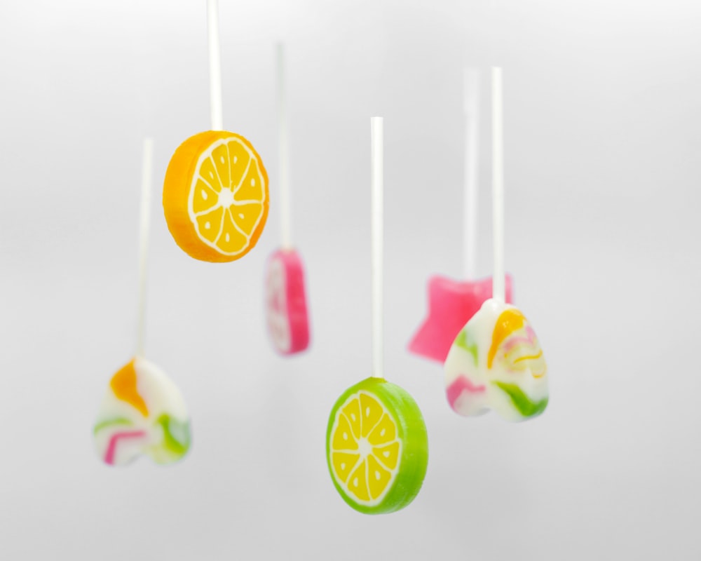 a group of fruit lollipops hanging from a string