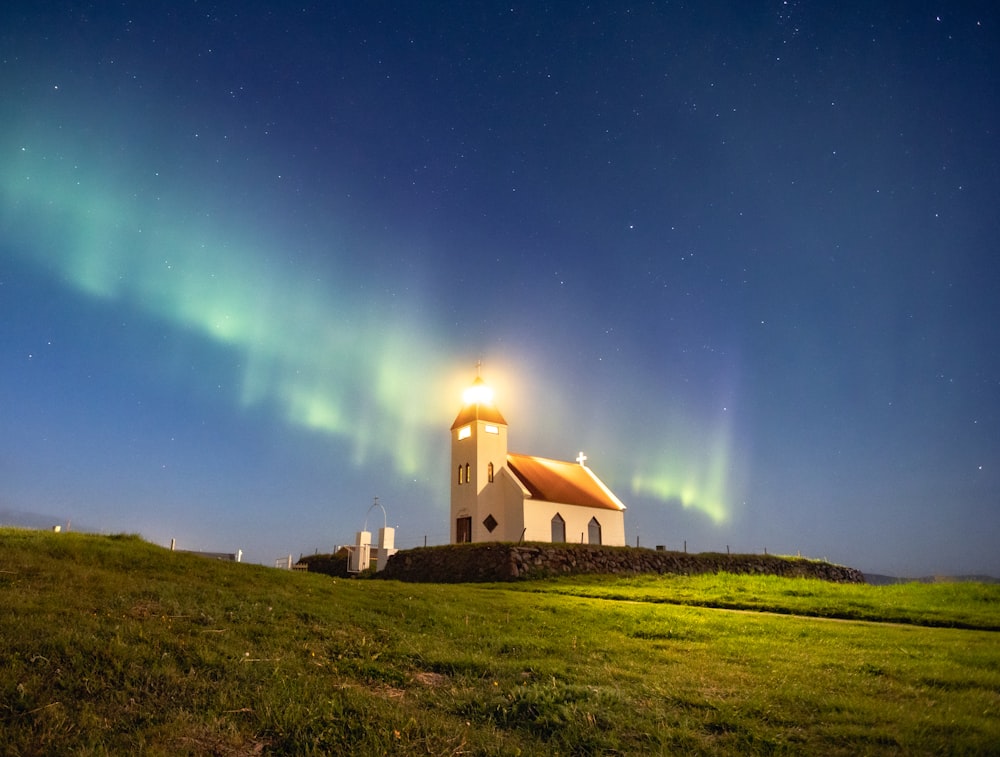 a small white church with a green light on top of it