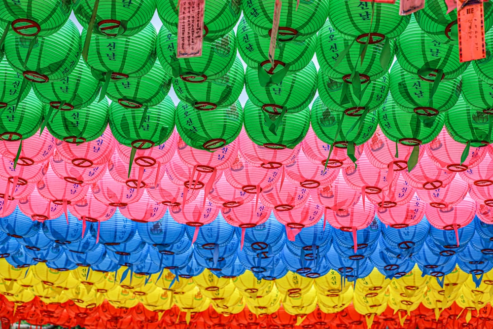 a bunch of colorful paper lanterns hanging on a wall
