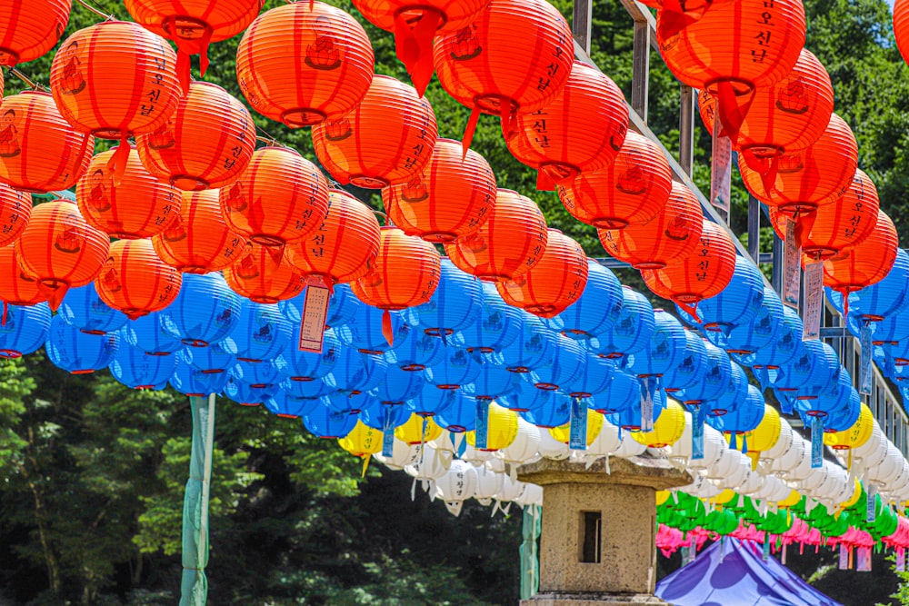 a bunch of red and blue lanterns hanging from the ceiling