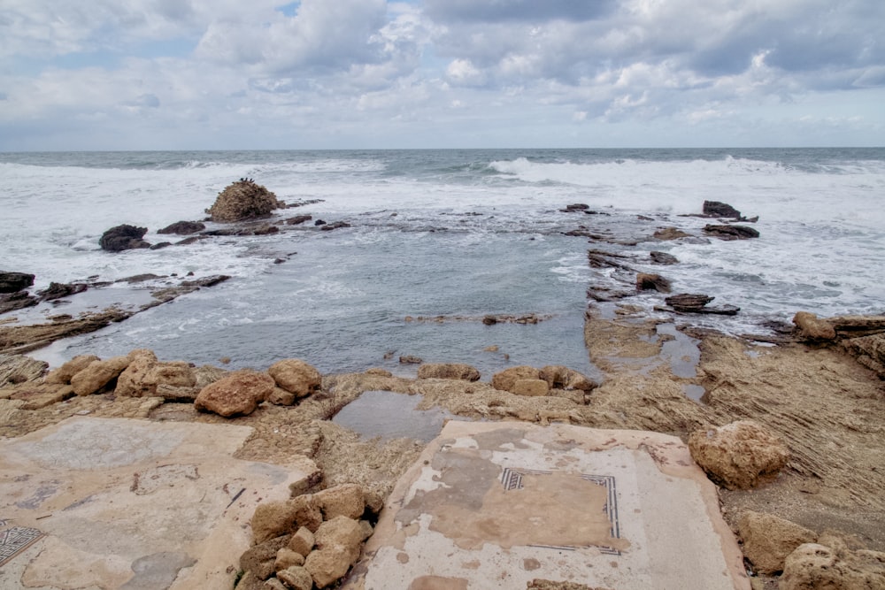 a rocky beach with a large body of water