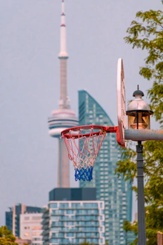 Dynamic urban scene with a basketball hoop framed by graffiti and city skyline.