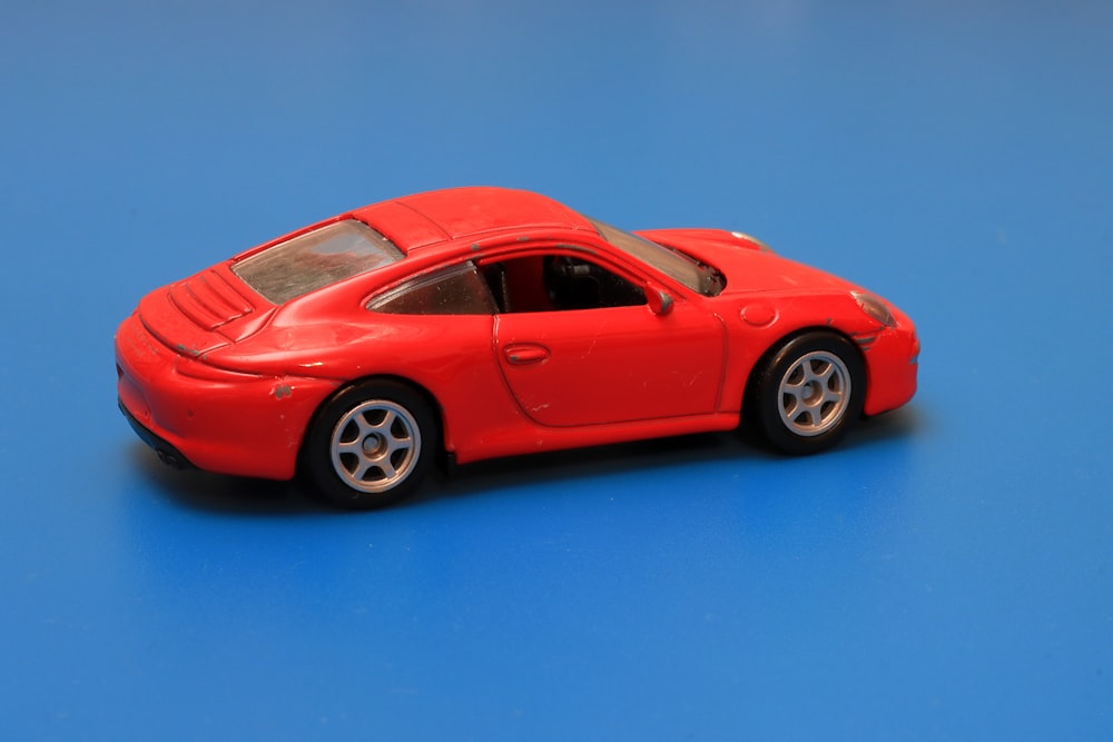 a red toy car on a blue surface