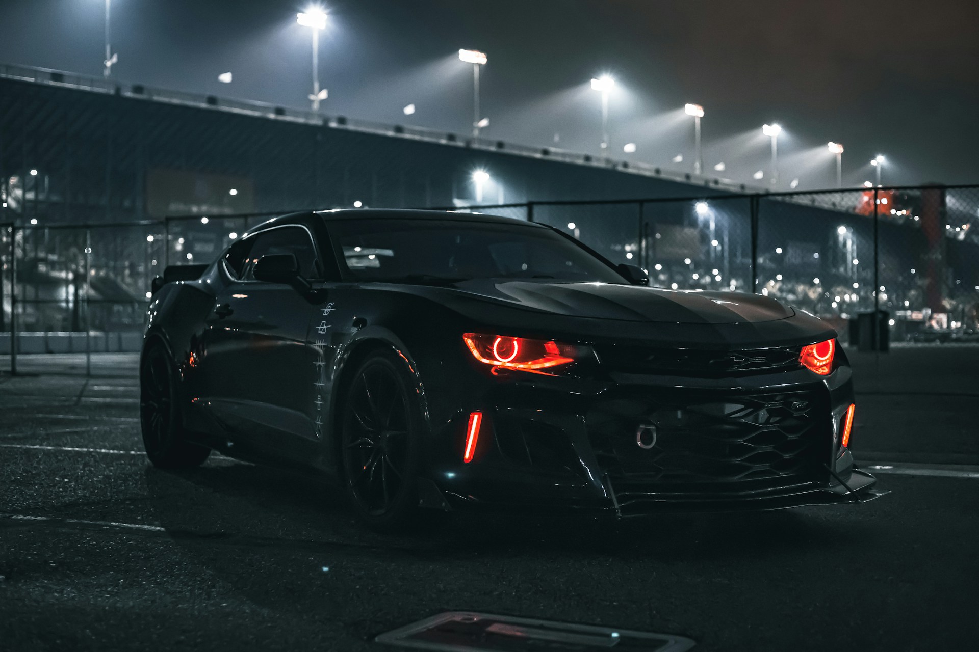 a black sports car parked in a parking lot at night