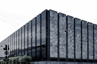 Modern building facade with visible electrical conduits and instrumentation.