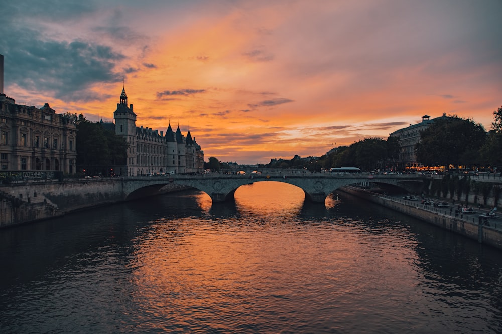 a bridge over a river with buildings in the background