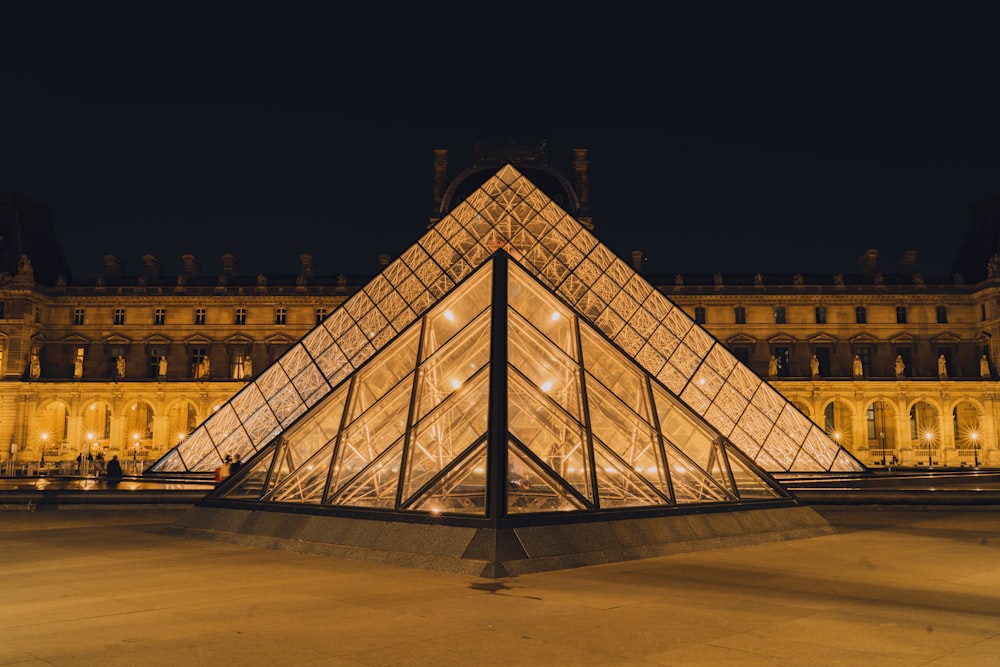 a large glass pyramid sitting in front of a building