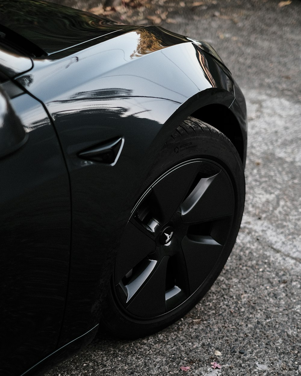 a close up of a black car parked on the street