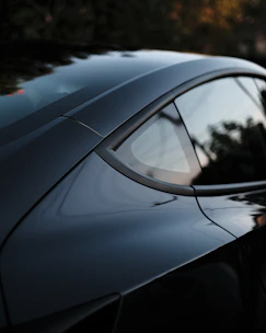 Close-up of a sleek car wrapped with an eye-catching ad driving through city streets.