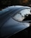 Close-up of a professional camera capturing a sleek car in natural light.