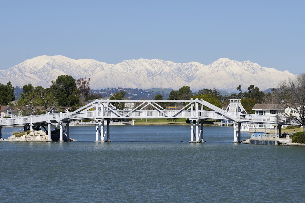 a bridge over a body of water with mountains in the background