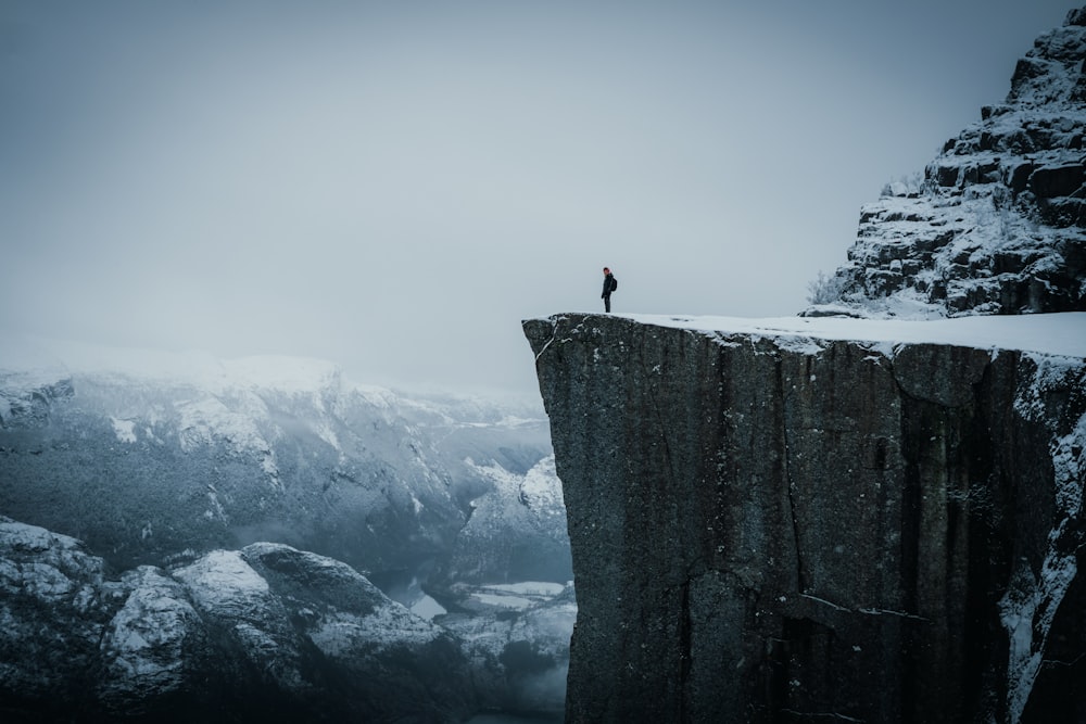 a man standing on top of a tall cliff