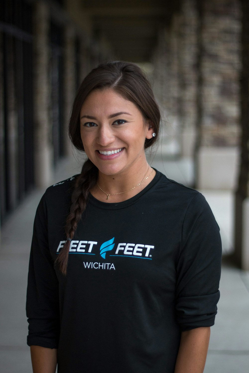 a woman standing on a sidewalk wearing a black shirt