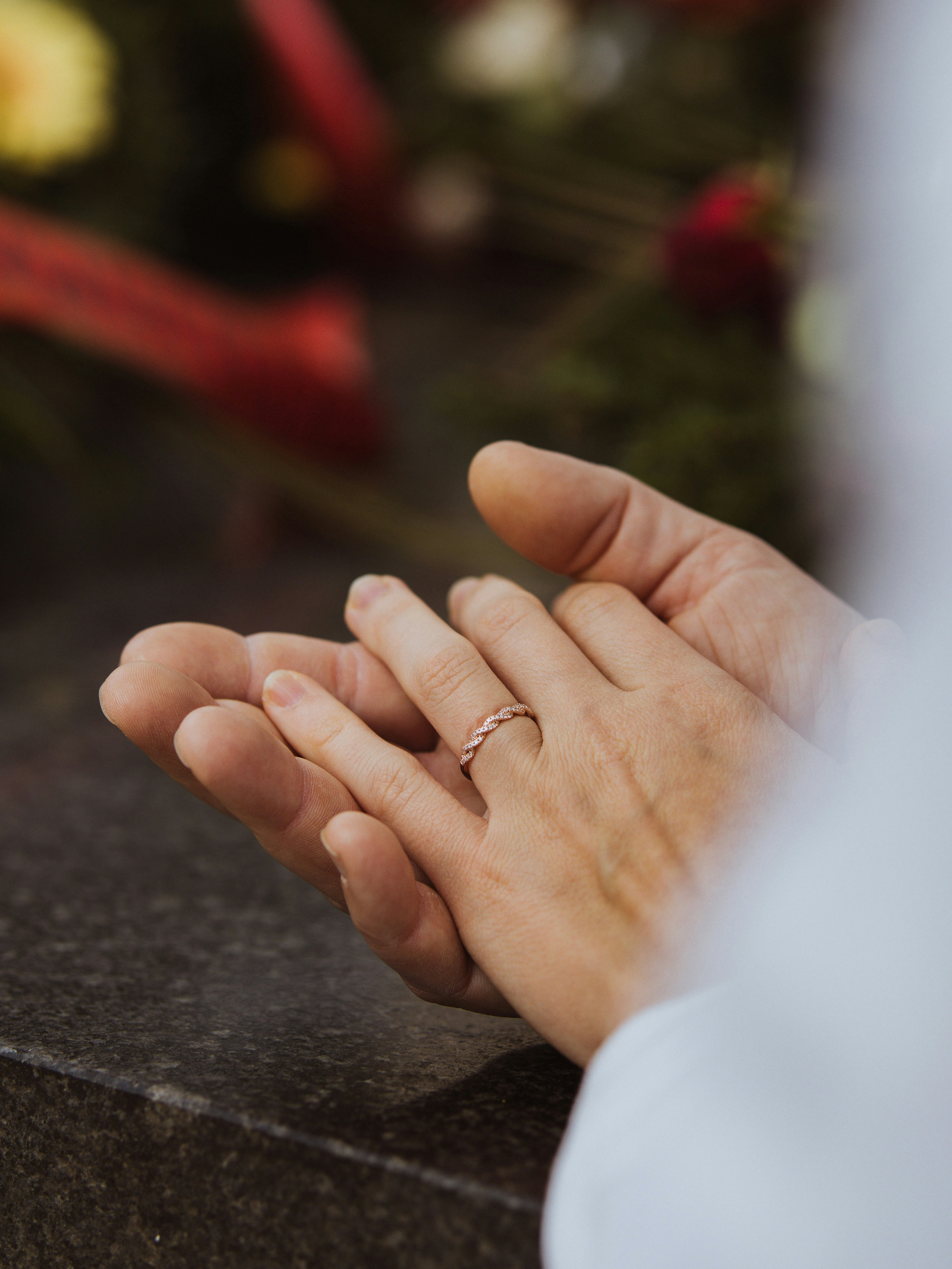 a close up of a person holding a wedding ring