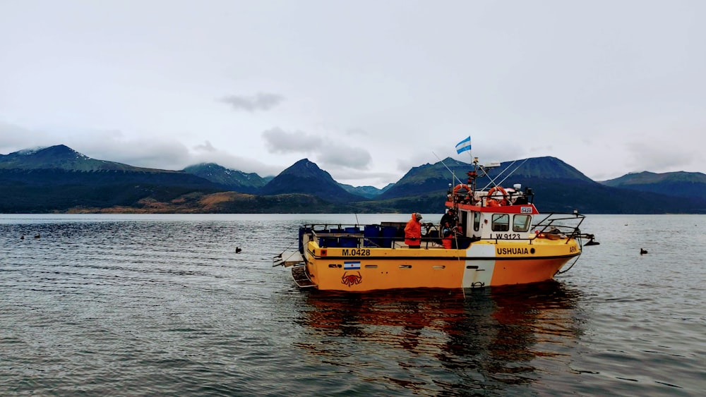 a yellow boat floating on top of a large body of water