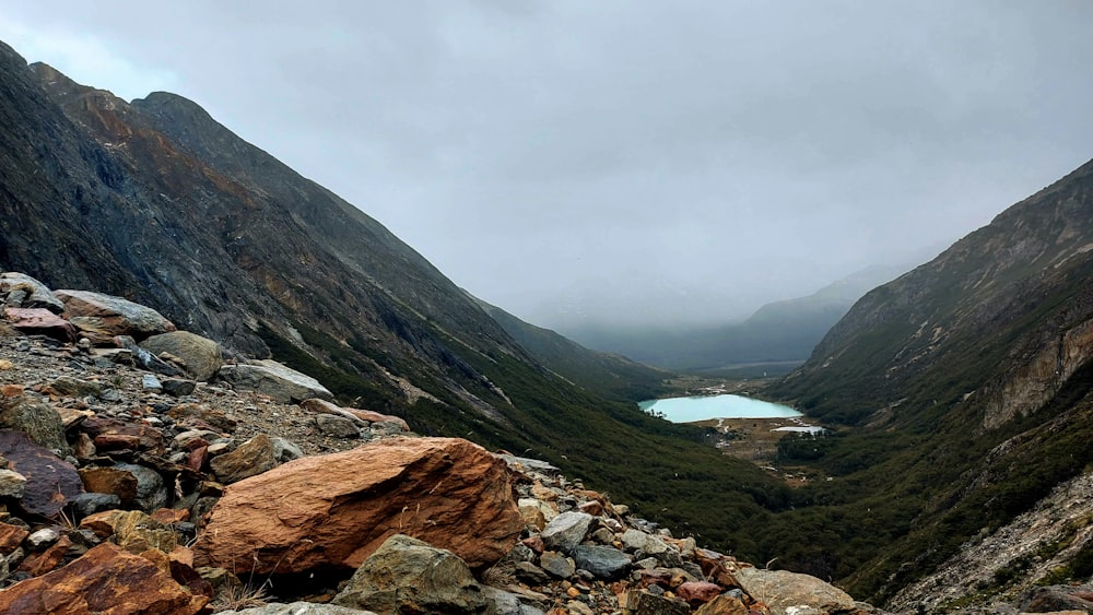 a view of a valley with a lake in the distance