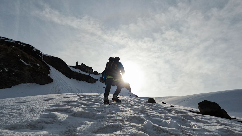 a man hiking up a snow covered mountain
