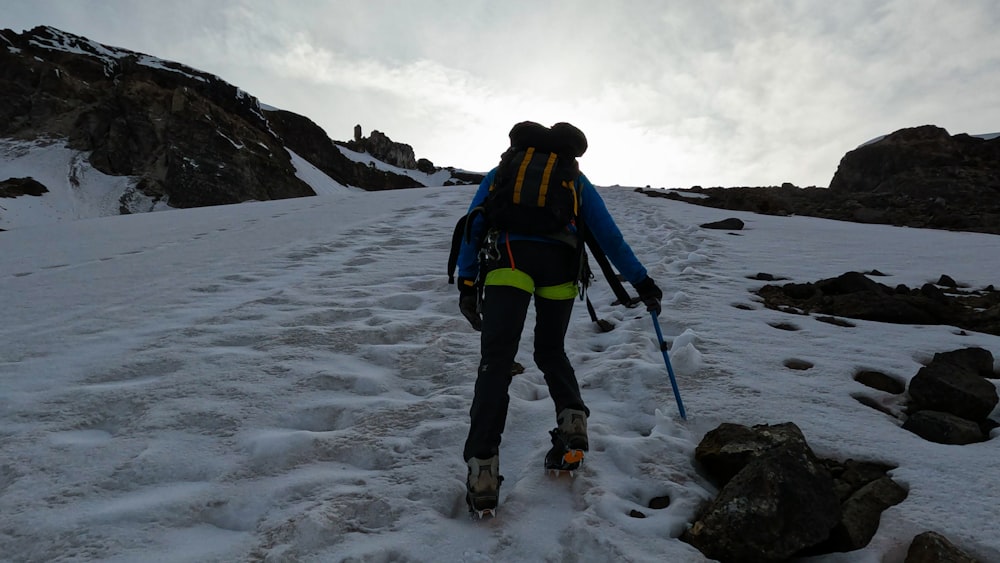 a person walking up a snowy hill with skis