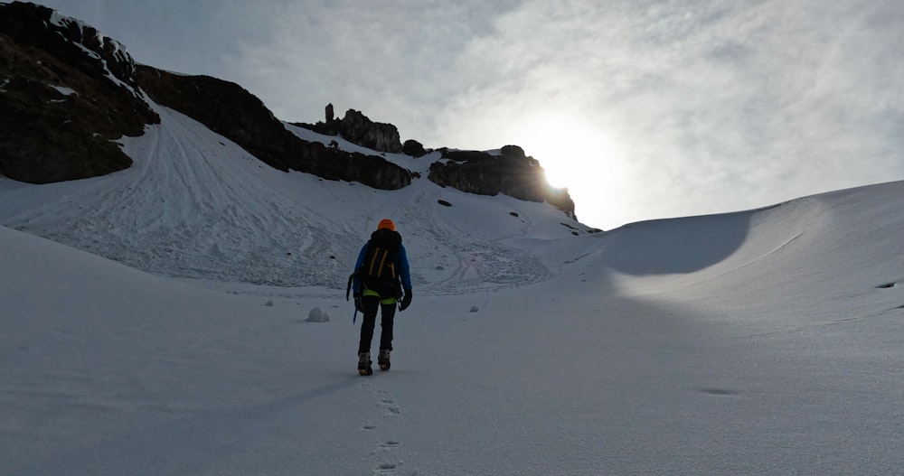 a person walking up a snow covered mountain