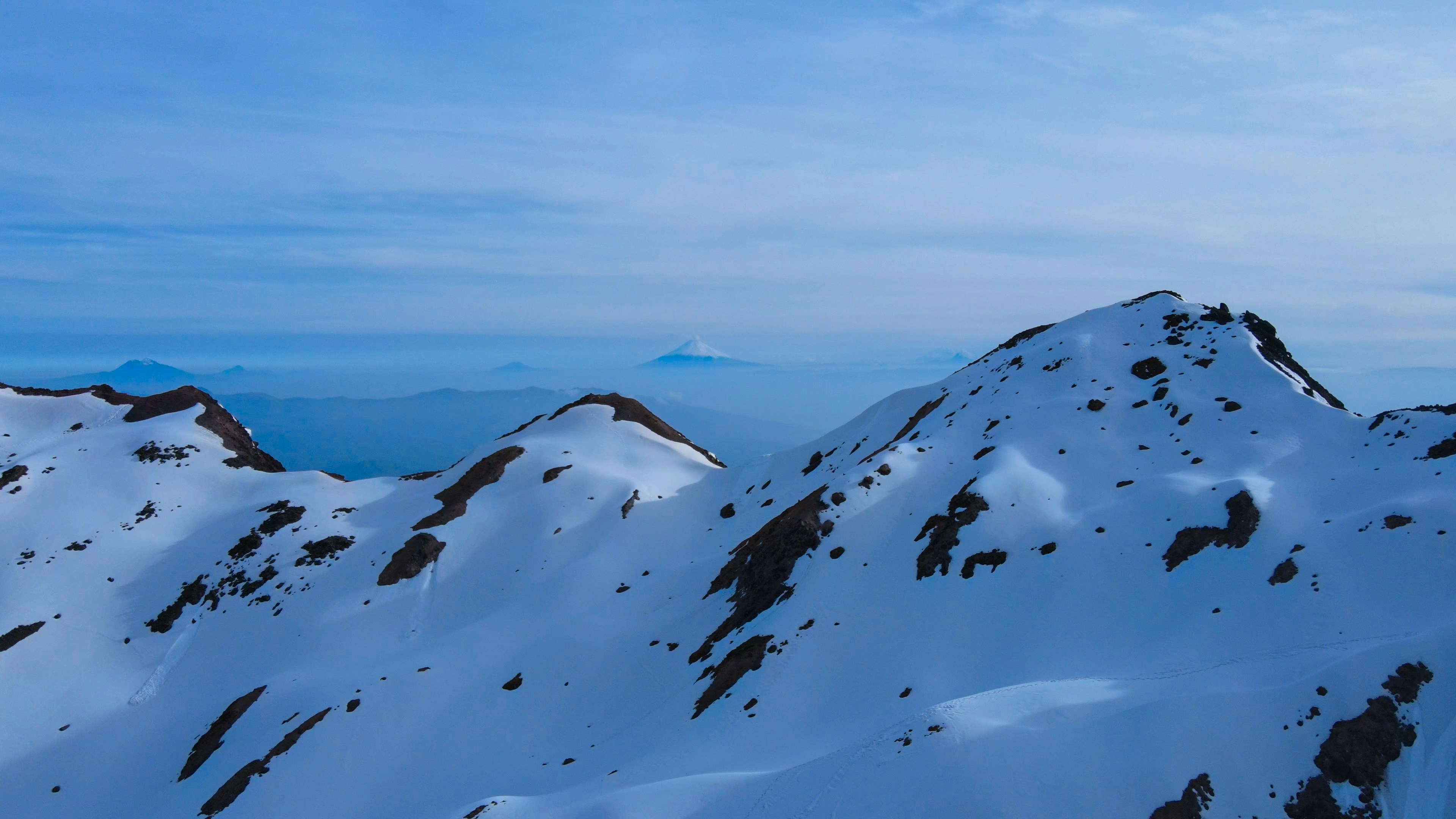 Una montaña cubierta de nieve con un fondo de cielo