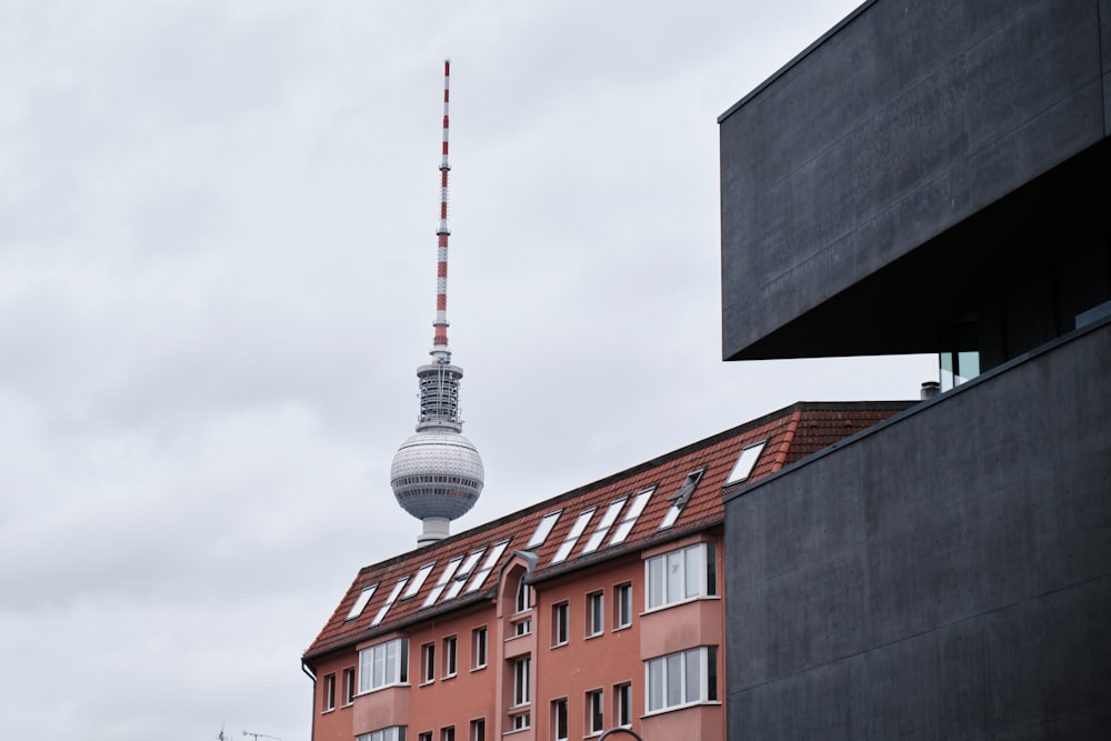 um edifício alto com uma torre de TV ao fundo