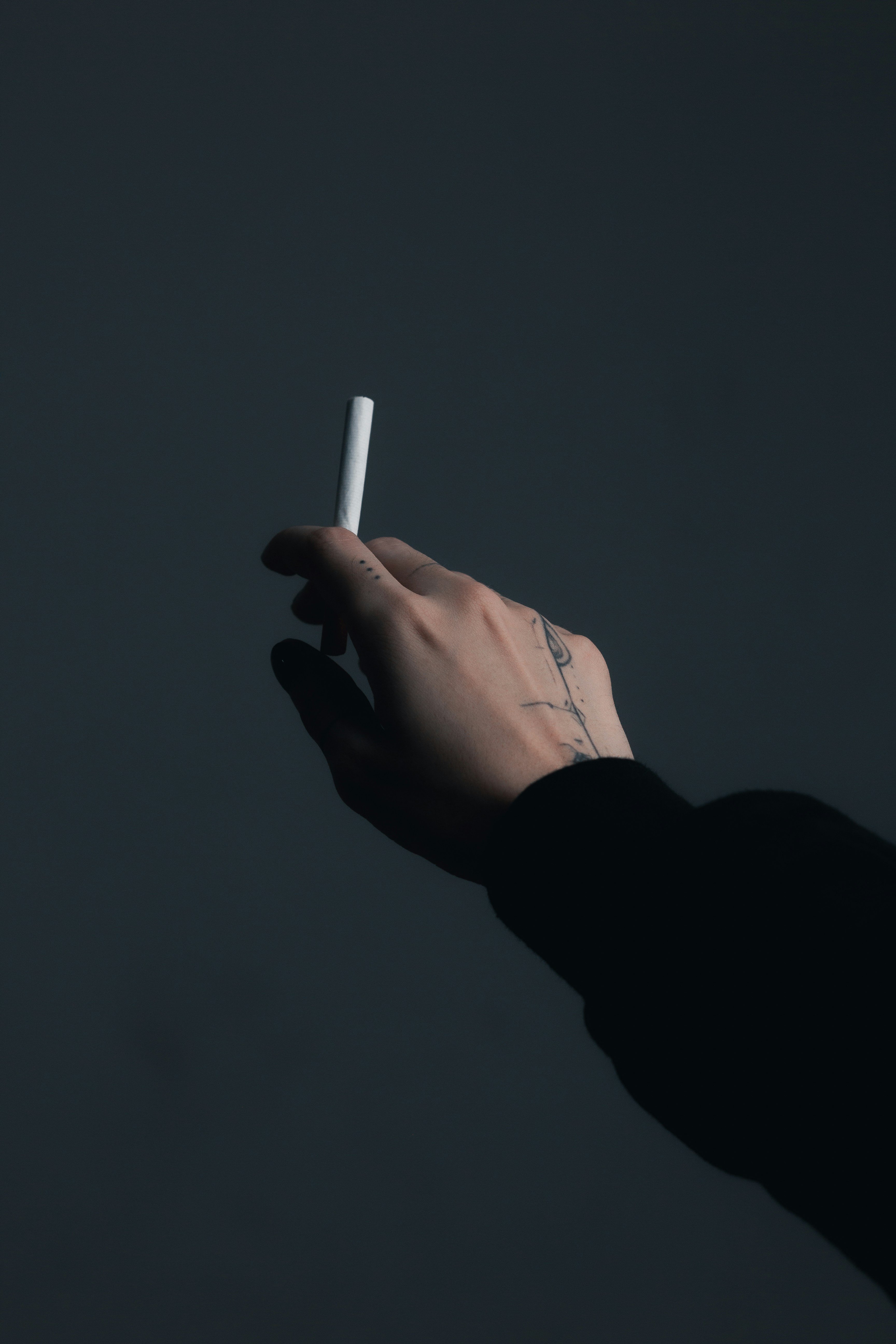 a person holding a cigarette in their hand