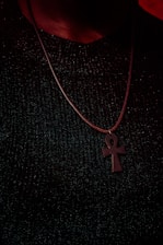 Close-up of a golden Ankh symbol resting on a dark blue textured background.
