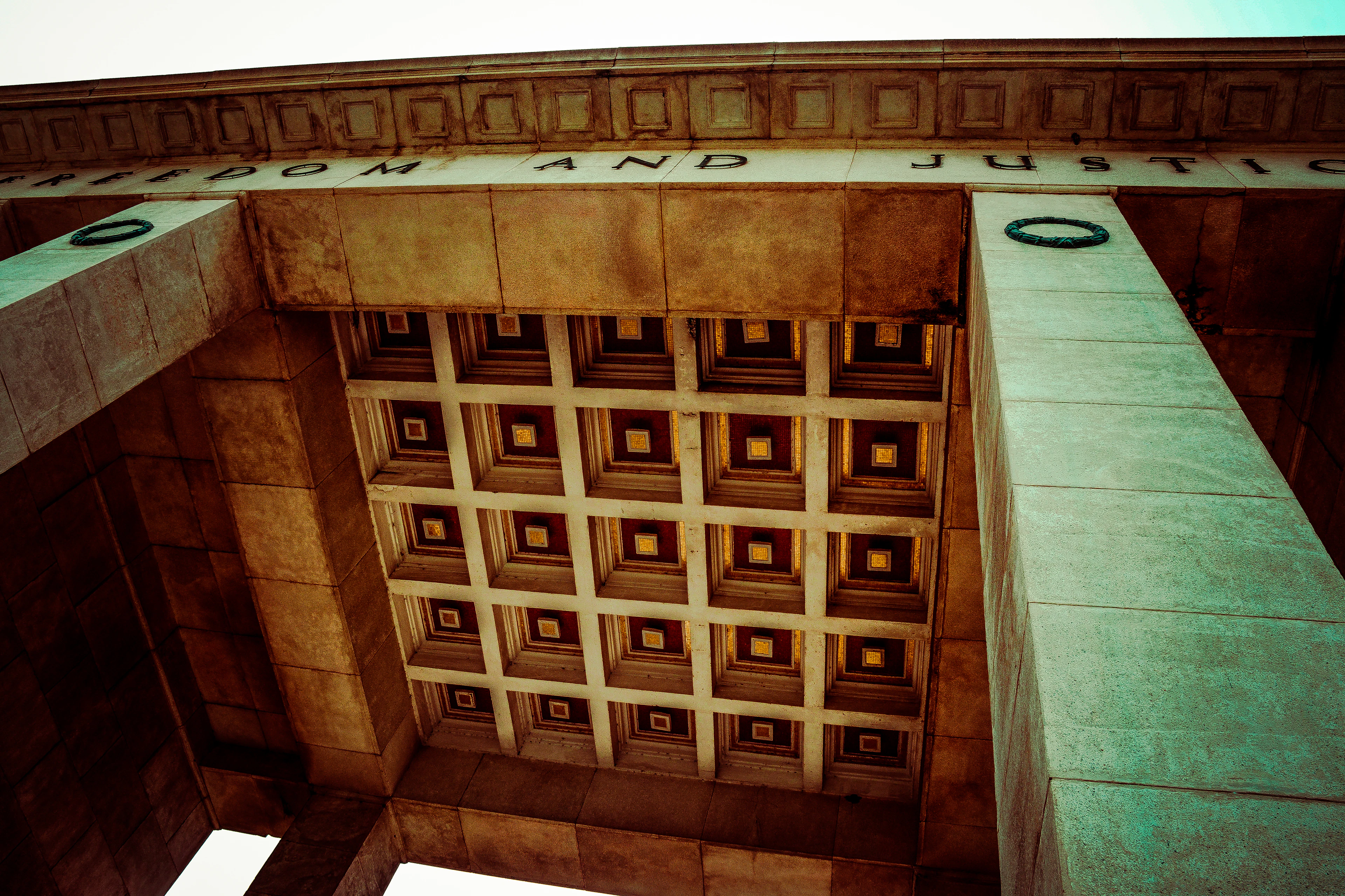 Looking straight up at the coffered underside of Accra's Independence Arch, inscribed 'Freedom and Justice.'
