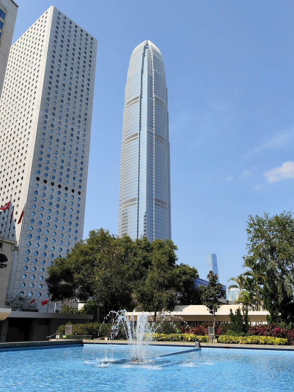 a fountain in the middle of a park with skyscrapers in the background