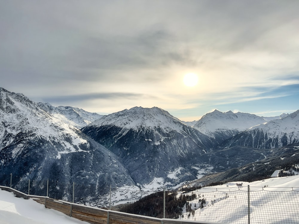 a view of a mountain range with a fence in the foreground