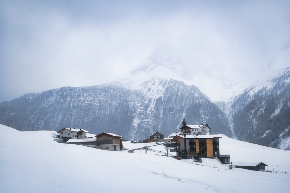 a snow covered mountain with houses in the foreground