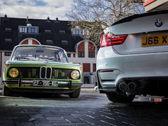a green car parked next to a white car