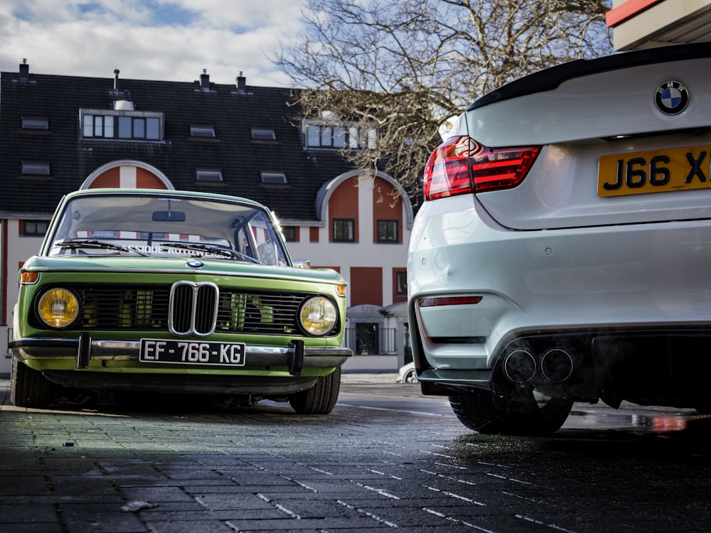 a green car parked next to a white car