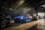 A line of well-maintained vehicles parked in a professional garage.