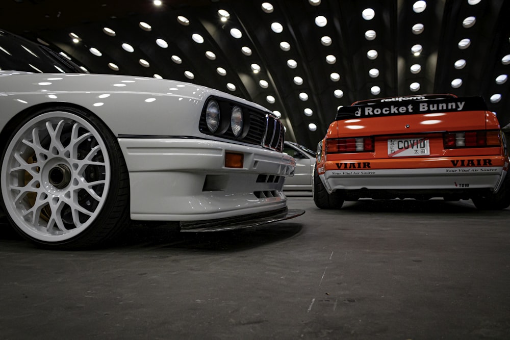 two cars parked next to each other in a garage