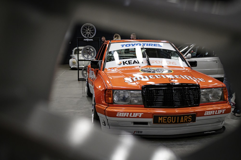 an orange and white car parked in a garage