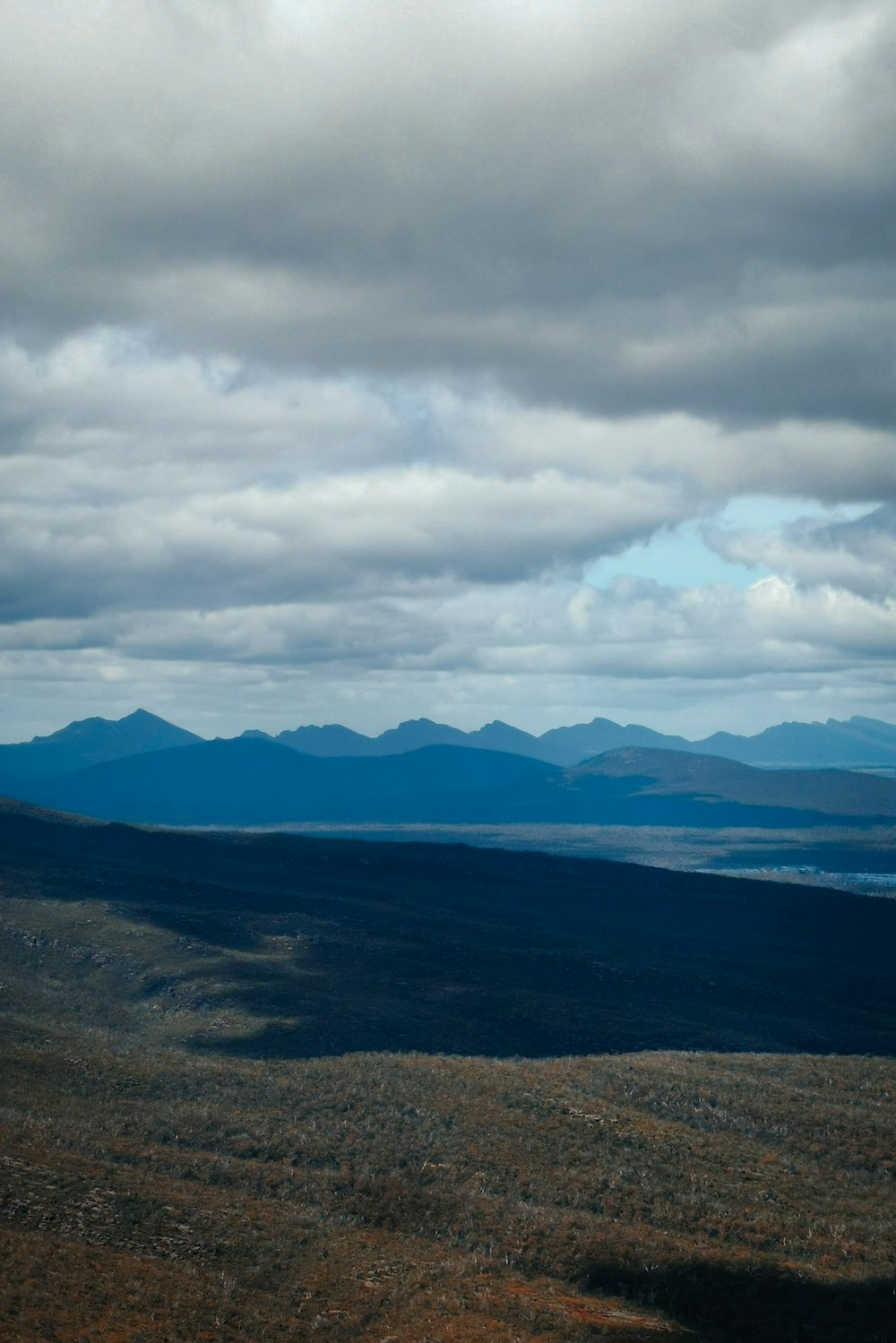 a view of a mountain range with clouds in the sky