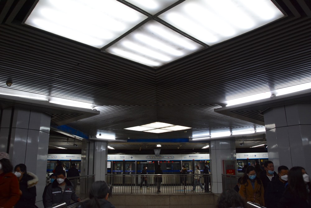 a group of people standing around a train station