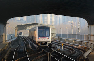 a train traveling through a train station next to tall buildings