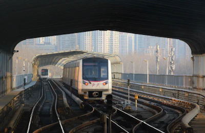 a train traveling through a train station next to tall buildings