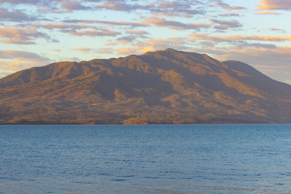 a large body of water with a mountain in the background