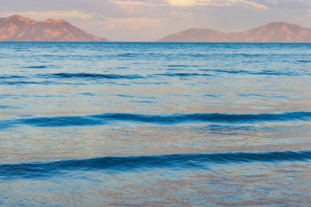 a large body of water with mountains in the background