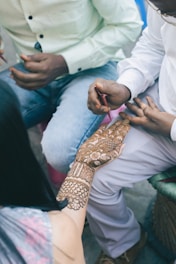 a woman getting a henna tattooed on her arm